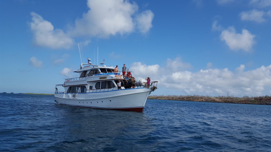A yacht sails the group between the Galápagos islands. 